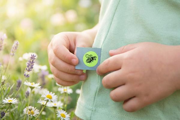 Hellblaues Faltetikett mit Bienenmotiv in Seitennaht eines Kindershirts