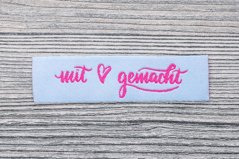 Webetiketten mit Liebe gemacht pink auf hellblau Polynera